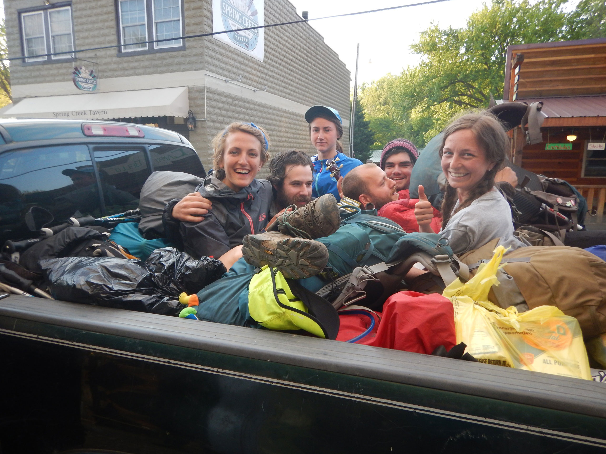 Thru-hikers piling into the back of a pickup to hitchhike